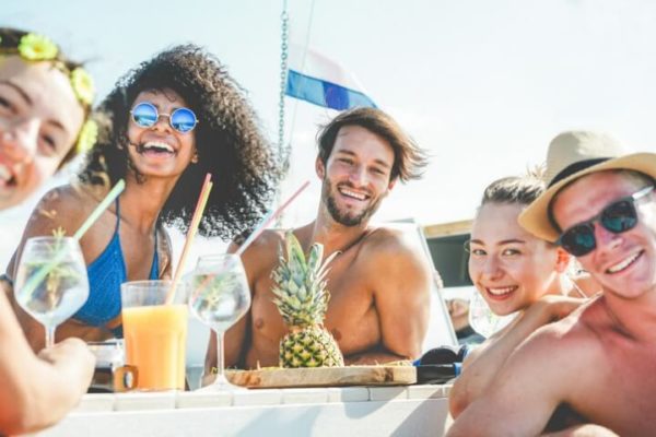 group-of-happy-friends-drinking-tropical-cocktails-at-boat-party-picture-id937868764-1