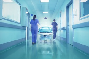 medical professionals wheeling a patient down a hospital hallway