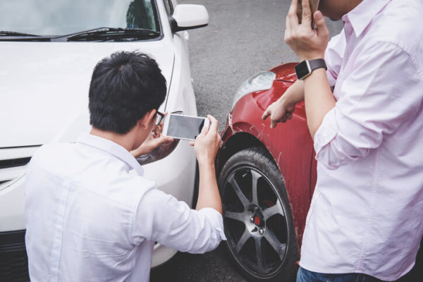 two men evaluating the damage of their cars after a car accident in miami