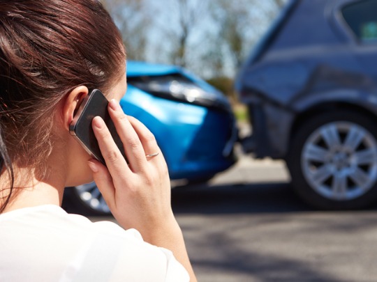 woman calling the police after a car accident