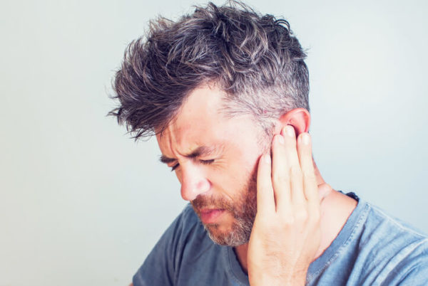 man grimacing with ear pain