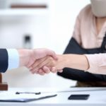 lawyer shaking hand of woman with a sling and neck brace