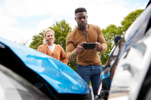 man takes picture of car accident and damage