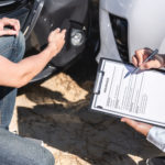 Insurance Agent examining car crash and customer assessed negotiation, checking and signing on report claim form process after accident collision, Accident and insurance concept.