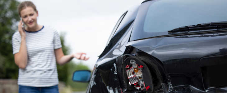 Unhappy Female Driver With Damaged Car After Accident Calling Insurance Company On Mobile Phone