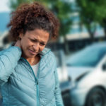 Woman suffering whiplash after bad cars pile up