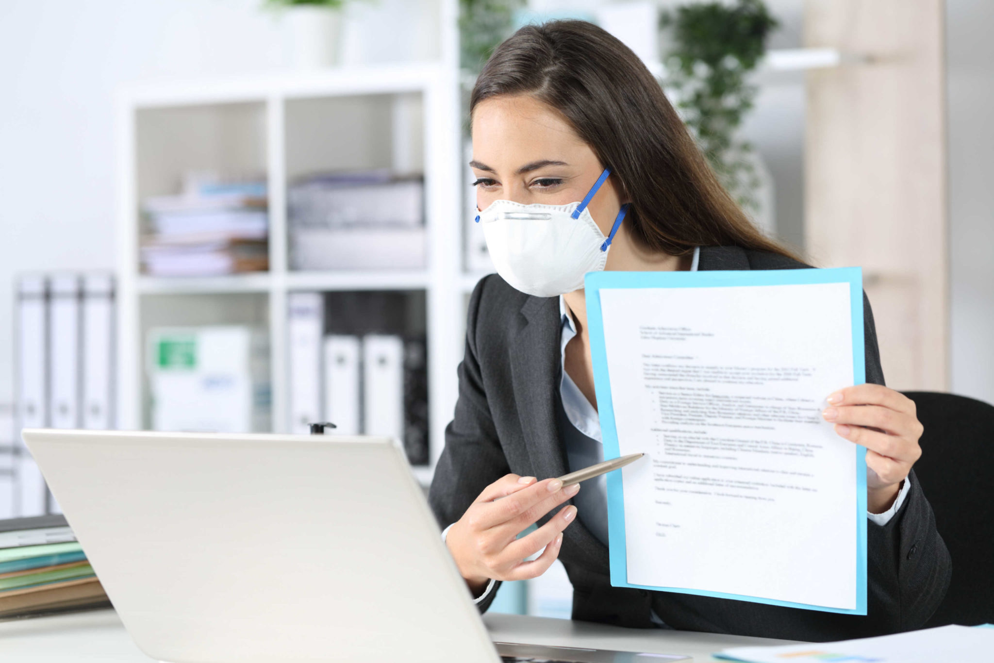 Executive with mask shows contract on videocall