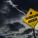 Hurricane season with symbol sign against a stormy background and copy space. Dirty and angled sign adds to the drama.