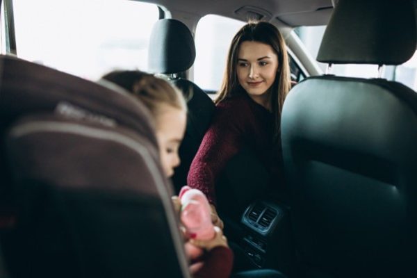 mother checking on child in car seat