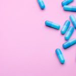 Weight loss pills on a pink background