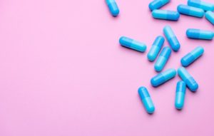 Weight loss pills on a pink background