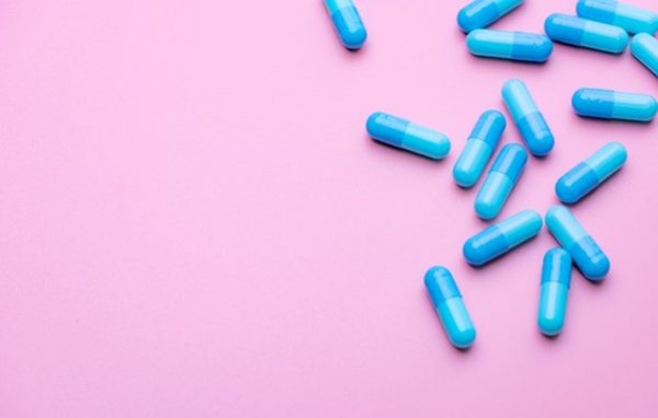 Weight loss pills on a pink background