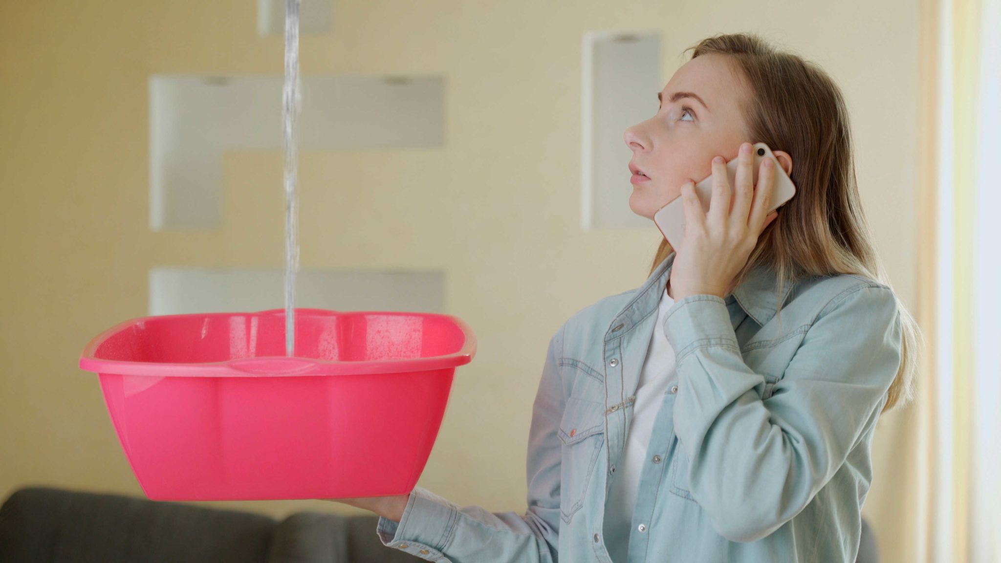 water leak girl on the phone after a hurricane because of a water leak in her roof