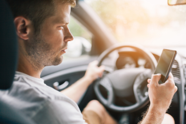 man texting while driving