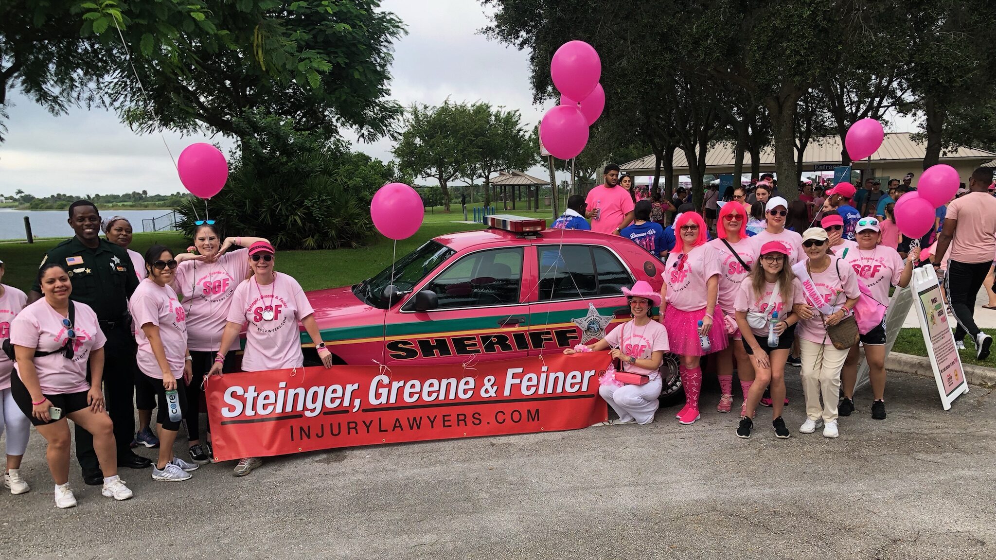 Steinger Greene and Feiner pose with West Palm Beach Sheriff's office car in pink for breast cancer research